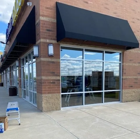 Commercial storefront glass replacement with new clear windows installed in a retail building.